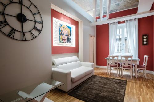 都灵都灵公寓的客厅配有白色沙发和墙上的时钟