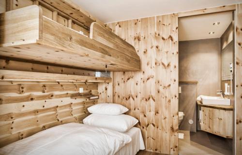 毛特恩多夫schaus Lüftenegger - Apart-Zirbenpension的卧室设有木墙和一张带白色枕头的床。