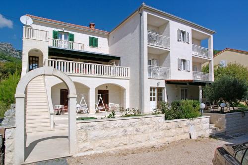 波尔Apartments Villa Adria Bol的一座白色的大房子,前面有拱门