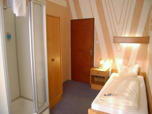 柏林普克勒伽弗酒店的一间带一张床和淋浴的小卧室
