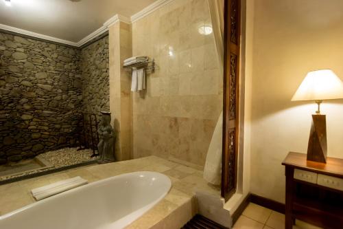乌布萨哈德瓦Spa度假酒店的带浴缸和台灯的浴室
