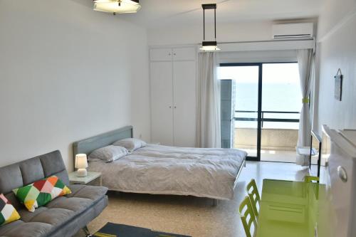 拉纳卡Stadem Studios的一间卧室配有一张床、一张沙发和一个窗口