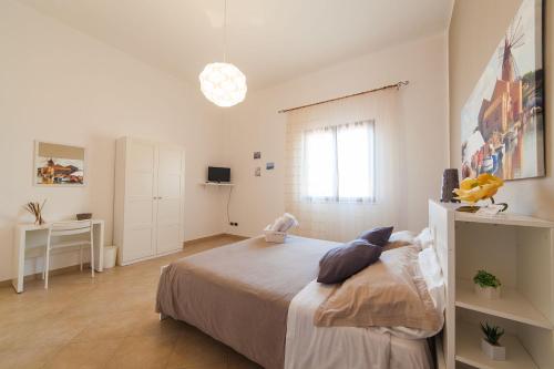 里里耶沃B&B Bianco Sale Trapani的白色卧室配有床和书桌