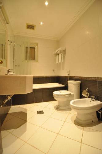 利雅德尼落芙阿拉达酒店的浴室设有2个卫生间、水槽和浴缸。