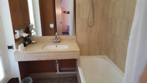巴黎美迪亚酒店的浴室配有盥洗盆和浴缸。