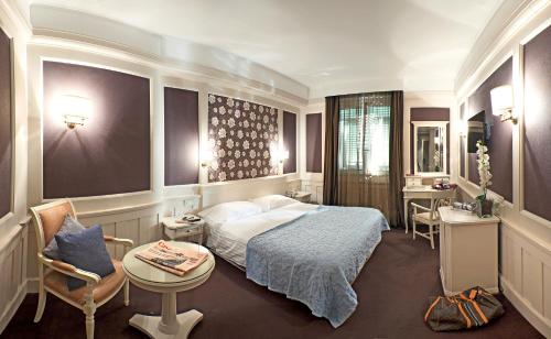 拉帕洛欧洲设计1877温泉酒店的酒店客房带一张床、一张桌子和椅子