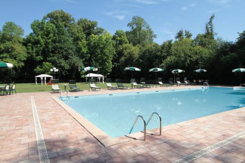 Pasiano di Pordenone卢比斯别墅酒店的一个带椅子和遮阳伞的大型游泳池