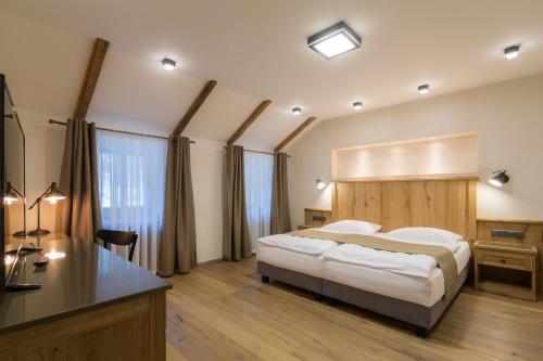 卡罗维发利马累凡尔赛酒店的一间卧室配有一张大床、一张桌子和一张书桌