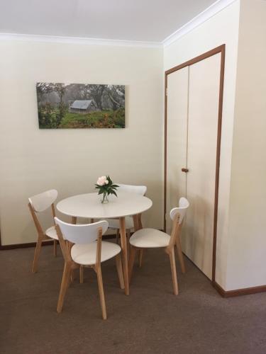 布赖特阿科恩度假屋的一间配备有白色桌椅的用餐室