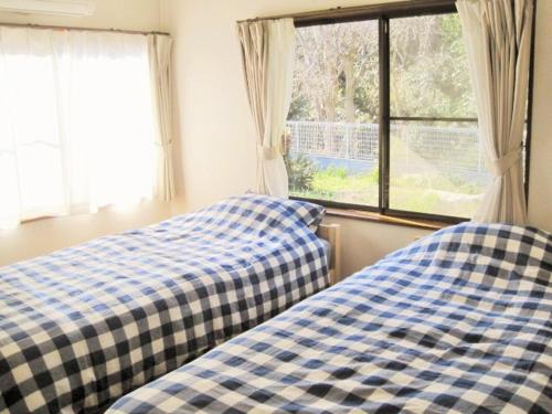 立山町果菜园厨房旅馆的卧室的窗户旁设有两张床
