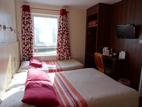 霍利盖特威克白宫酒店的酒店客房设有两张床和窗户。
