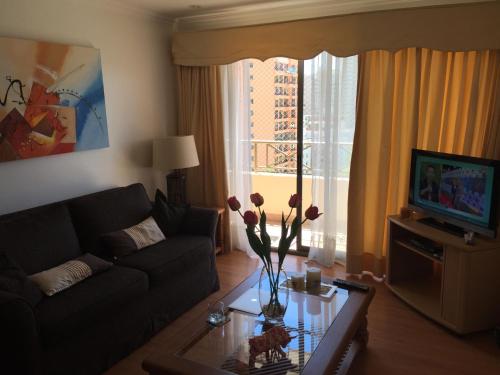 维纳德马Apartamento Edificio Genova的客厅配有沙发和鲜花桌