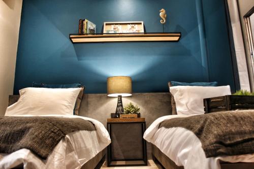 沙美岛Ku at sea的一间卧室设有两张床和蓝色的墙壁