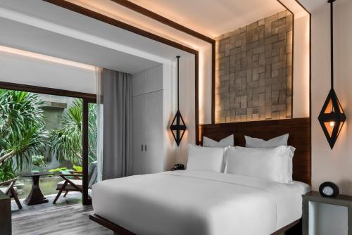 暹粒河流公园贾耶之家度假村的卧室设有白色的床和大窗户