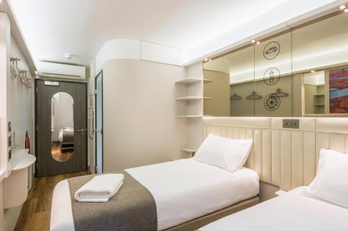 伦敦伦敦金丝雀码头点A酒店的一间卧室配有两张床和镜子