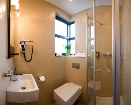 凯撒斯劳滕佐拉蒙特设计酒店的浴室配有卫生间水槽和淋浴。