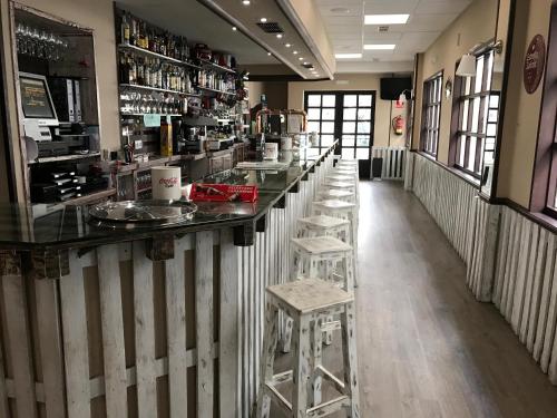 费罗尔Hostal La Frontera的餐厅中间的酒吧,带凳子