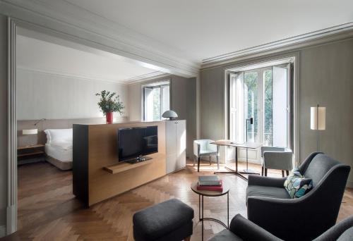 巴塞罗那巴塞罗那GL阿尔玛酒店的客厅配有电视、沙发和床。