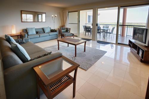 玛志洛河上公寓酒店的客厅配有沙发和桌子
