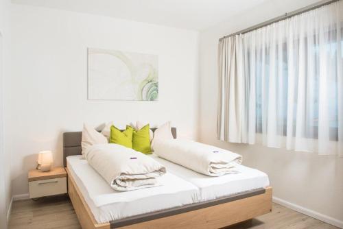 弗拉绍Villa Valentine的一间卧室配有一张带白色和绿色枕头的床