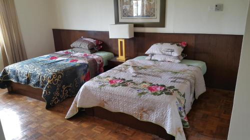 马六甲亚罗牙也法摩沙D萨沃伊三卧室公寓的一间卧室配有两张床和一盏灯