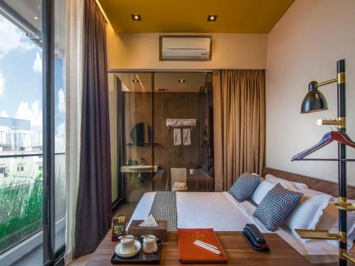新加坡Hotel Yan的酒店客房设有一张床和一个大窗户