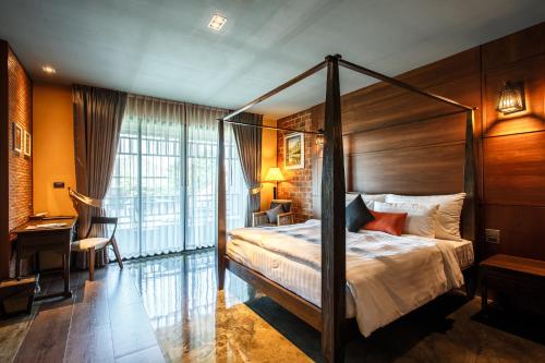 Prakhon ChaiHotel de l'amour SHA PLUS的一间卧室配有一张天蓬床和一张书桌