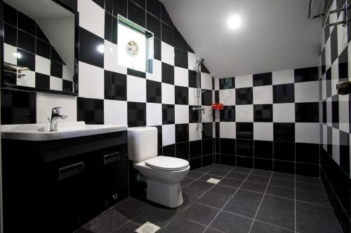 金马仑高原The Bala's Holiday Chalet的黑白浴室设有卫生间和水槽