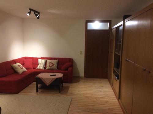 洛弗附近圣马丁Grubhof的客厅配有红色的沙发和桌子