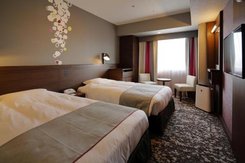 福冈福冈蒙特埃马纳酒店的酒店客房设有两张床和一台平面电视。