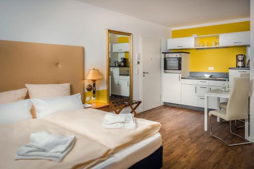 格赖夫斯瓦尔德Hanse-City-Boardinghouse的酒店客房带一张床和一个厨房