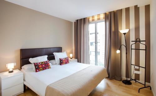 巴塞罗那度勒特海滩公寓的卧室设有白色的床和大窗户