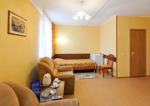 梁赞洛维奇体育酒店的酒店客房,配有床和沙发