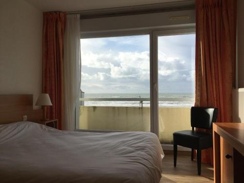 马翁普拉日堡特拉斯酒店的一间卧室配有一张床,享有海滩美景