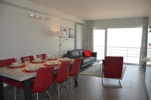 奥斯坦德4B @ Longchamp的一间带桌子和红色椅子的用餐室