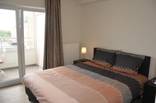 奥斯坦德4B @ Longchamp的一间带大床的卧室和一个阳台