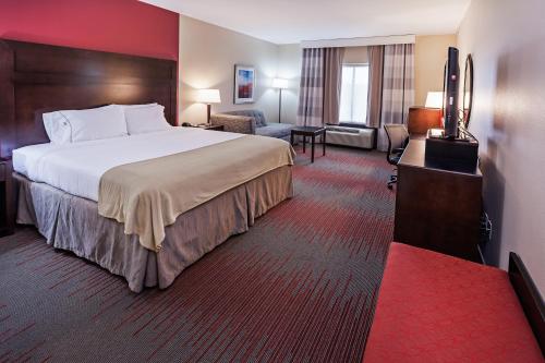 Duncan邓肯智选假日套房酒店的酒店客房设有一张大床和一间客厅。