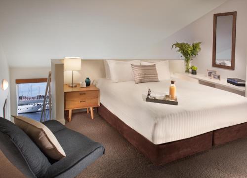 霍巴特皮尔萨默塞特酒店的一间卧室配有一张大床和一把椅子