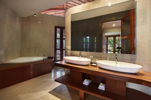 金巴兰Casa Bonita Villa Bali的浴室设有2个水槽、浴缸和镜子