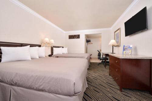艾尔蒙特Hotel Heritage的酒店客房配有两张床和一张书桌
