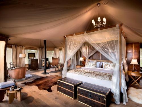 巴纳吉塞伦盖蒂One Nature Nyaruswiga营地的一间帐篷内带天蓬床的卧室