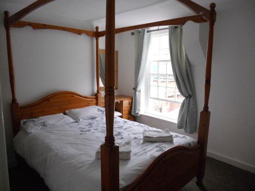 亚姆Yarm View Cottages的一间卧室设有天蓬床和窗户。