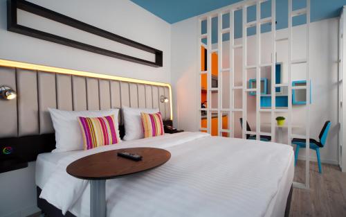里加里加巴罗纳丽柏酒店的一间卧室配有一张木桌和一张床铺。