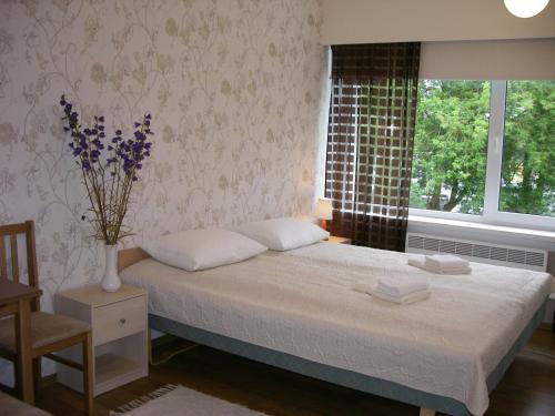 SalmeSõrve Guest House的一间卧室,床上放着花瓶
