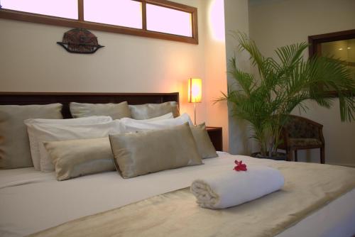 科科波拉波波种植园度假村的白色的床,有白色的枕头和红色的星