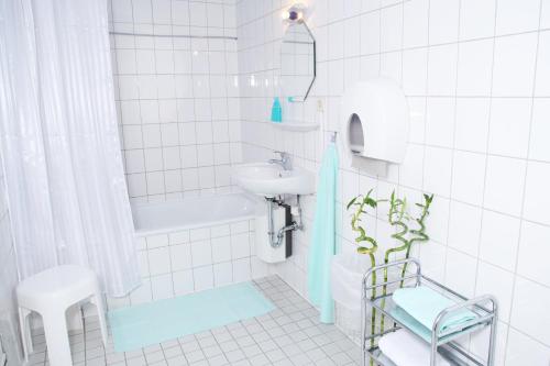 汉堡拉豪斯旅馆的白色瓷砖浴室设有水槽和卫生间