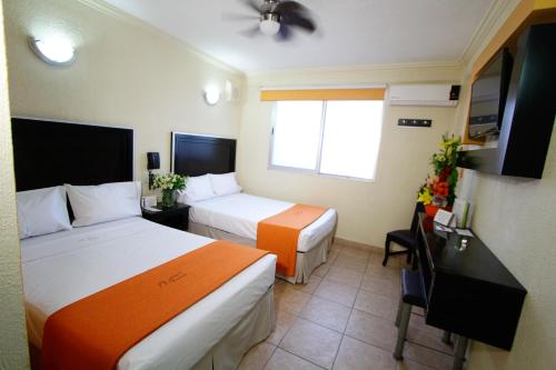 瓜达拉哈拉艾斯塔迪奥酒店的酒店客房配有两张床和一张书桌