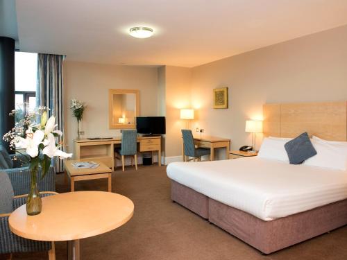 克劳道金Green Isle Hotel, Dublin的配有一张床和一张书桌的酒店客房