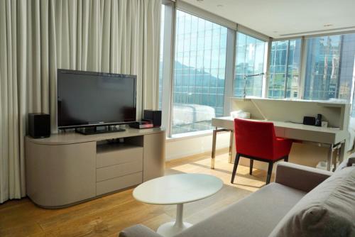 香港第二十一威菲路酒店的客厅配有平面电视和钢琴。