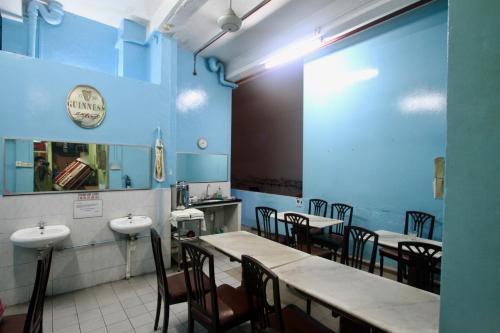 新加坡Backpacker Cozy Corner Guesthouse的一间配备有桌椅的用餐室和蓝色的墙壁